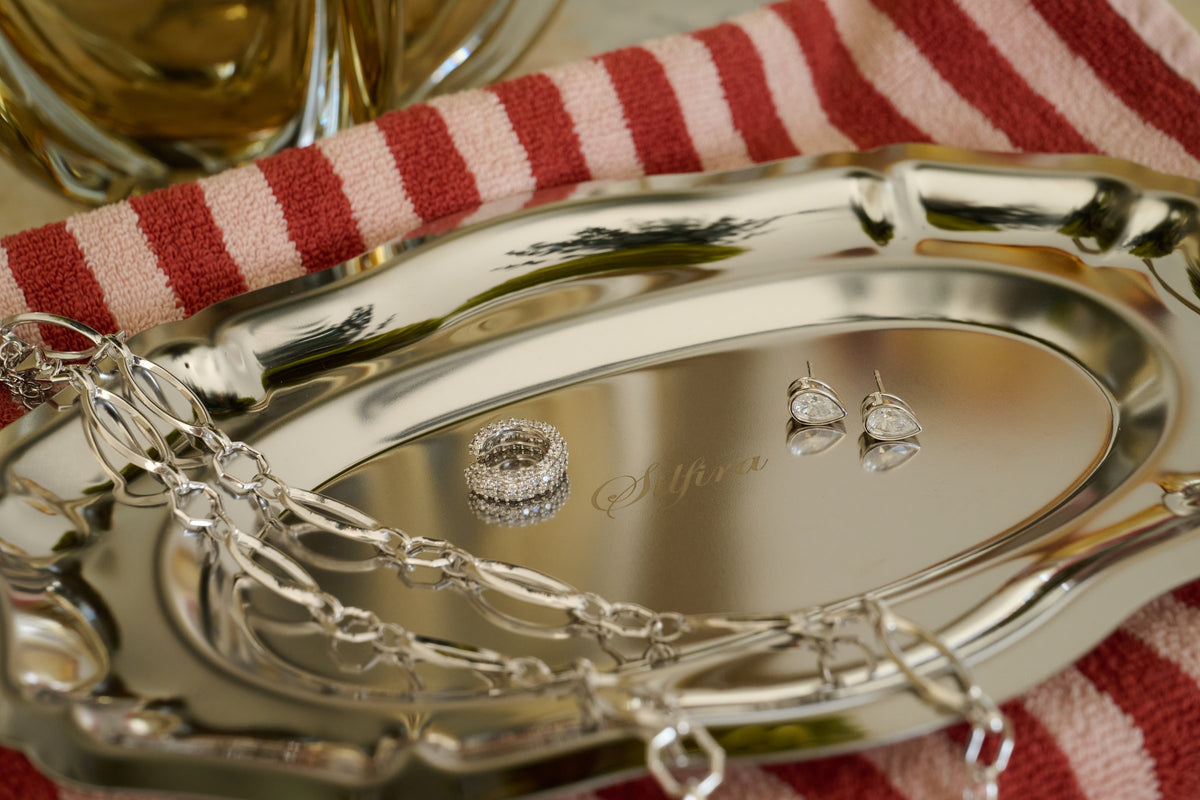 Bezel Pear Moissanite Studs on a silver Silfira tray, close up